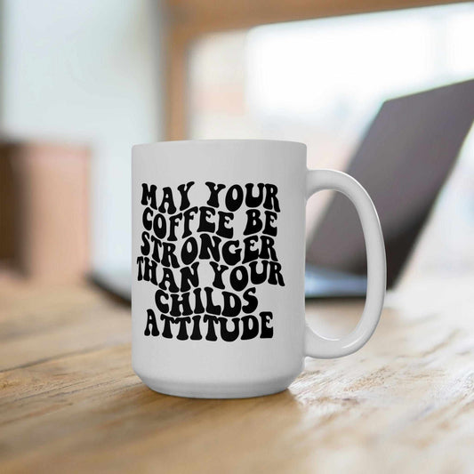 Funny mother's day coffee mug with saying "May Your Coffee Be Stronger Than Your Child's Attitude" in black text on a 15oz ceramic mug.