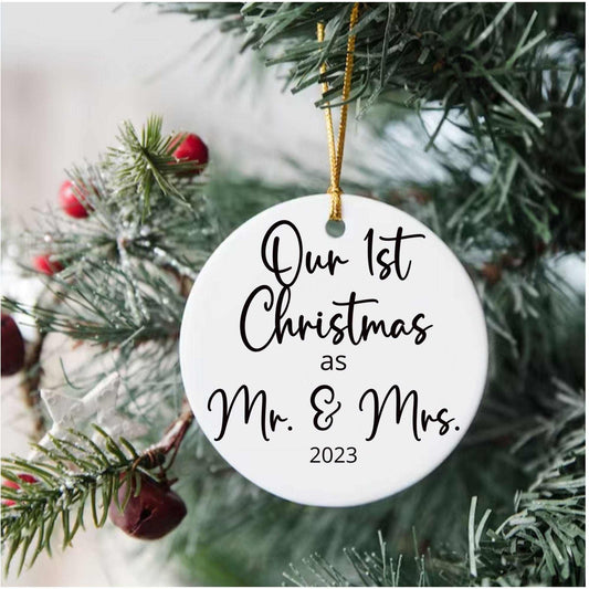 Personalized white porcelain Christmas ornament reading Our 1st Christmas as Mr. & Mrs. 2023 hanging on a tree with gold string