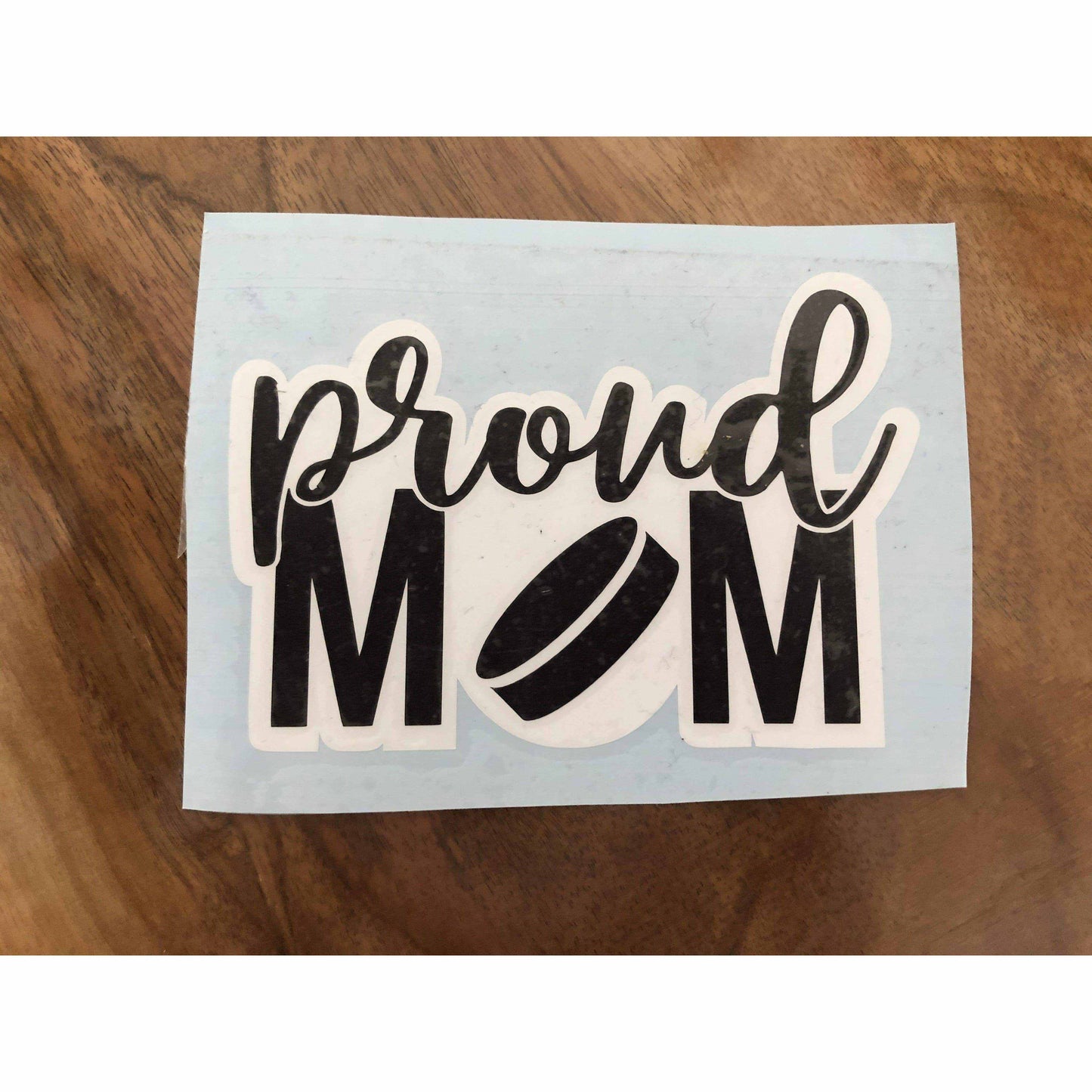 Proud Sport Mom sticker decal with football design on wooden surface