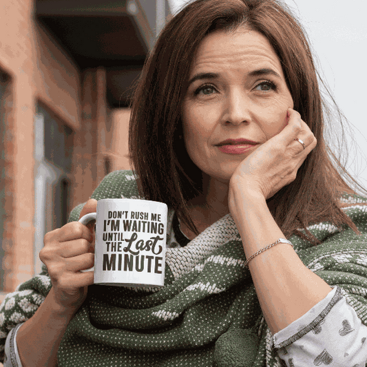 Ceramic coffee mug with "Don't Rush Me" design held by a woman.