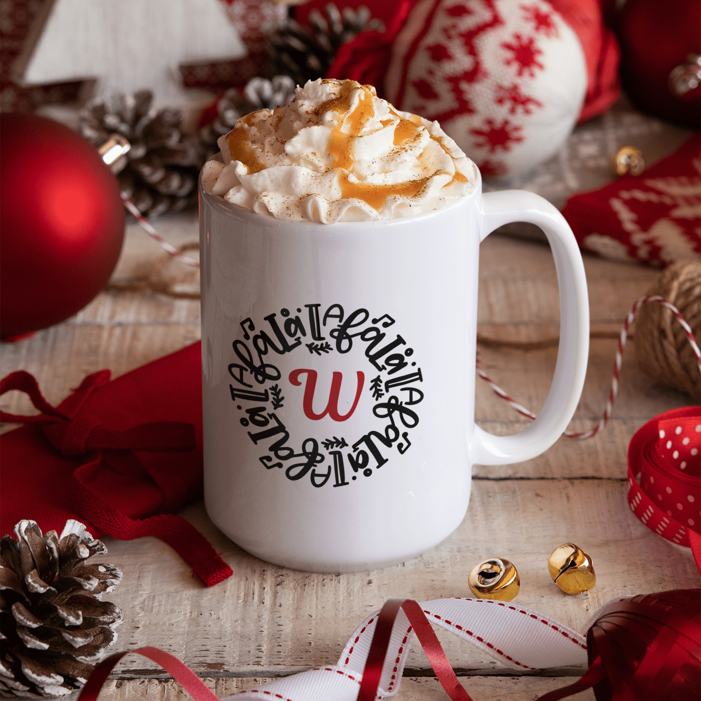 Personalized Christmas mug with whipped cream, surrounded by festive decor, featuring a custom initial design.