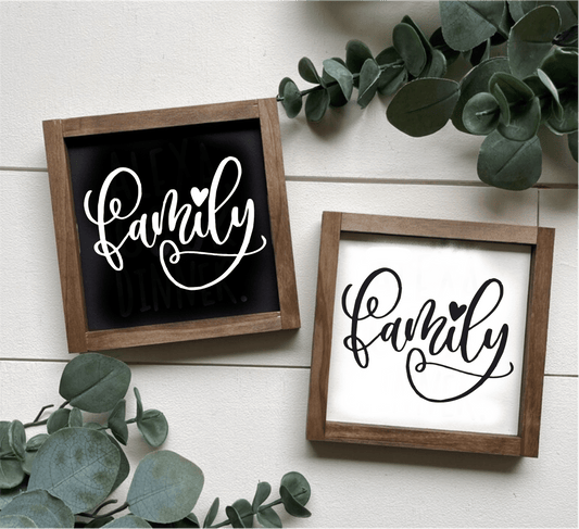 Handcrafted family wood signs with black and white lettering, natural wood frames, and greenery decoration.
