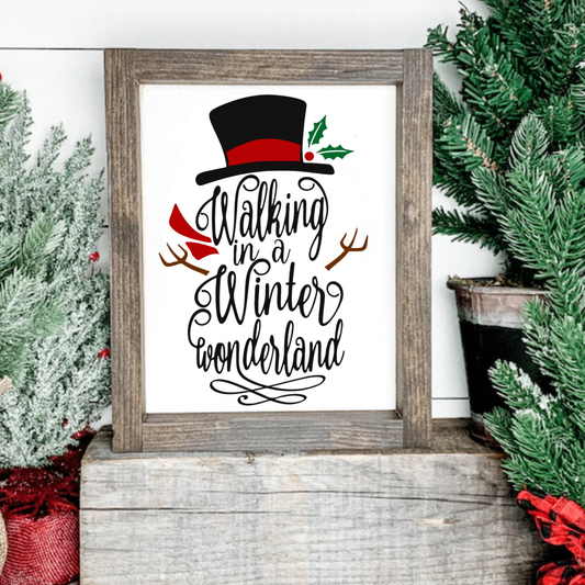 Festive snowman sign with "Walking in a Winter Wonderland" text, top hat, and red scarf on a wood frame.