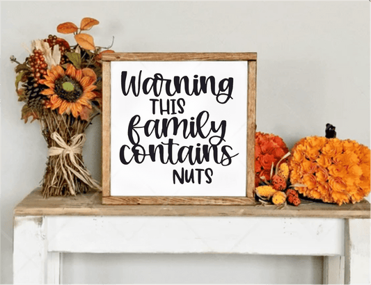Funny handcrafted wood sign with "Warning This Family Contains Nuts" text, framed in natural wood. Perfect for home decor or as a unique gift.