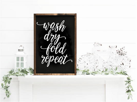 Handcrafted Wash Dry Fold Repeat wood sign with white script on black, framed in natural wood, ideal for laundry room decor.