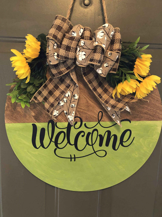 Handmade wood welcome door sign with floral and ribbon accents.