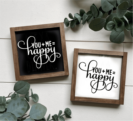 Handcrafted "You Plus Me Equals Happy" wood sign with black and white options, framed and decorated with greenery.