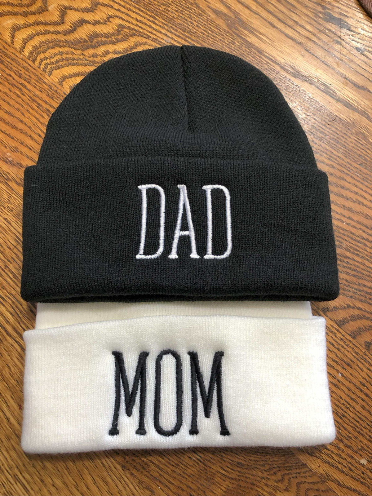embroidered beanies in white and black with names 'Mom' and 'Dad'
