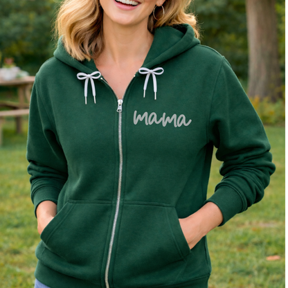 Person wearing a green hoodie with 'mama' embroidered on it, standing outdoors.