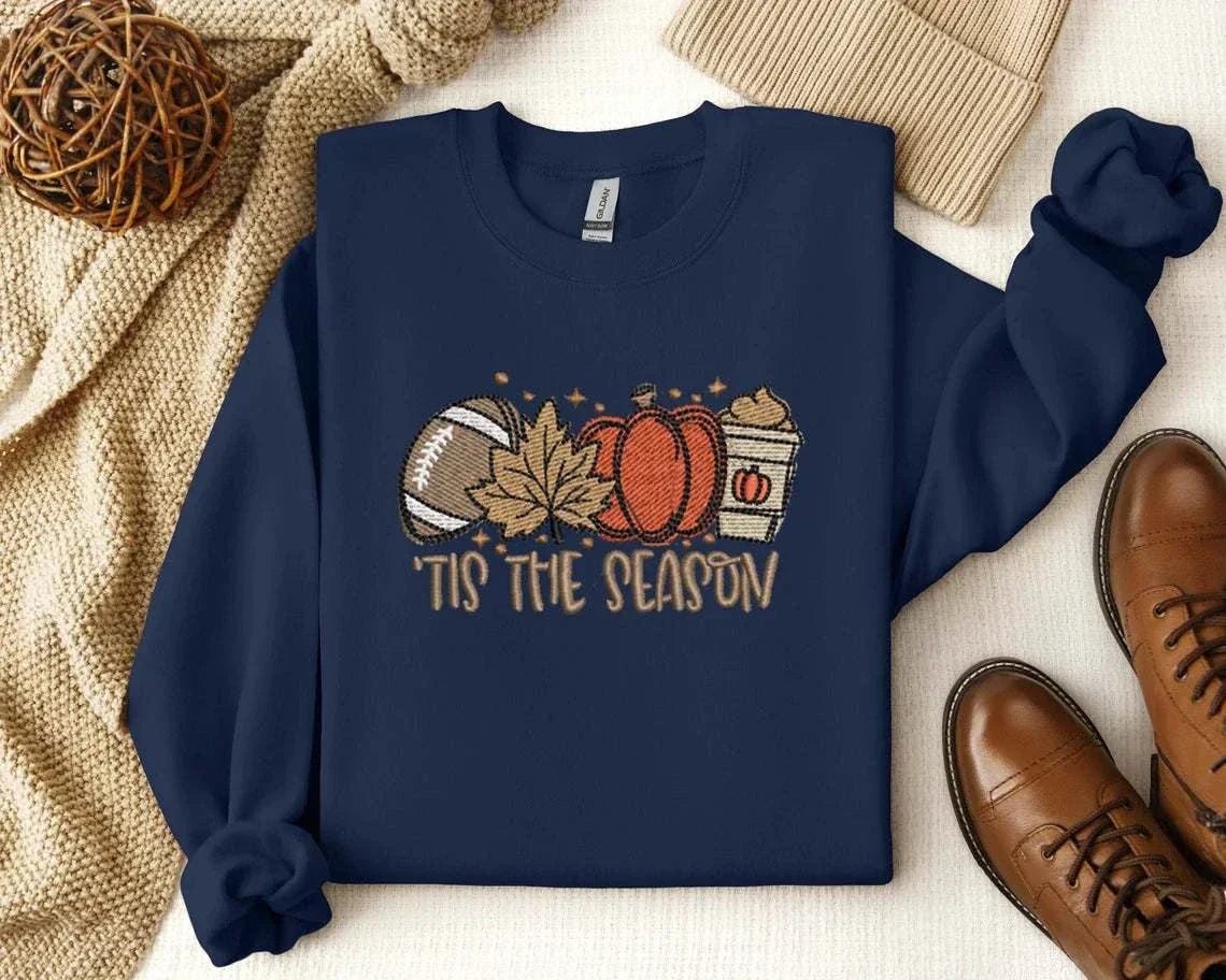 Embroidered Pumpkin Spice Latte Shirt with autumn-themed design featuring football, maple leaf, pumpkin, and latte, reading 'Tis the Season'.