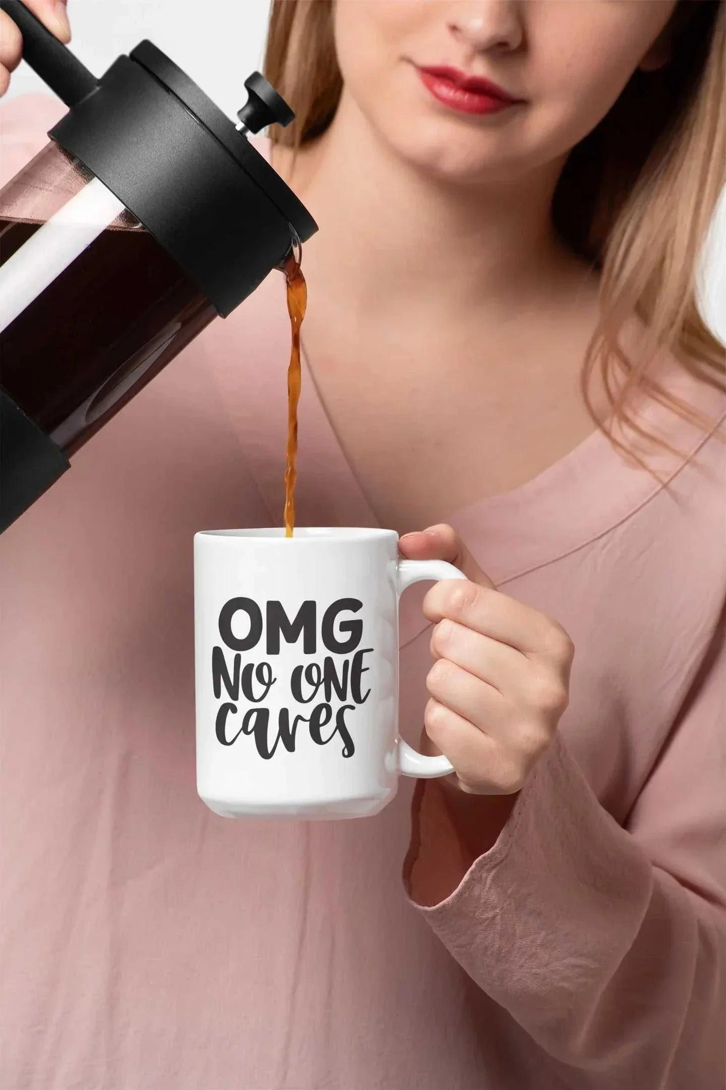Woman pouring coffee into white ceramic mug with "OMG No One Cares" black text sarcastic design