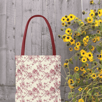 Pink Toile Tote Bag with flower print, reusable canvas, stylish and multi-purpose, next to vibrant yellow flowers.