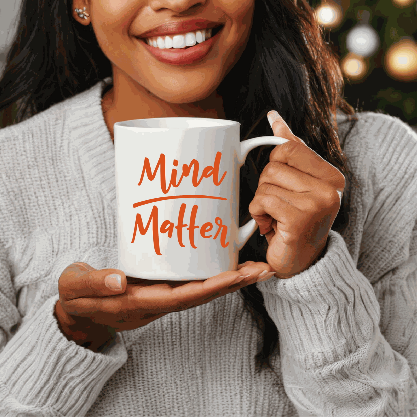 Woman holding "Mind over Matter" inspirational ceramic mug.