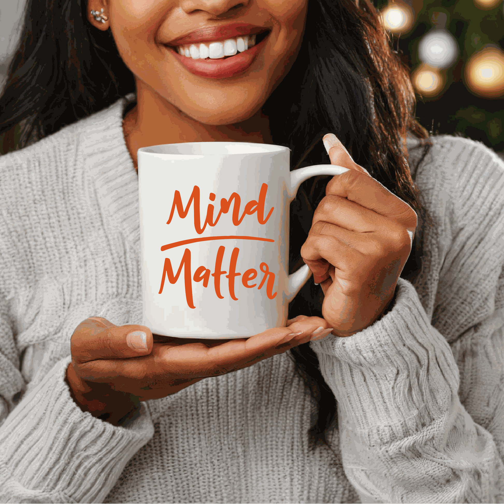 Woman holding "Mind over Matter" inspirational ceramic mug.