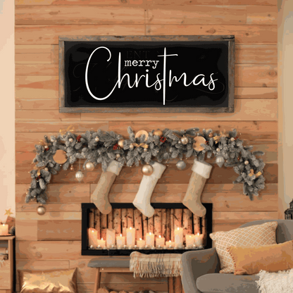 Handmade Merry Christmas wood sign with black background and white script lettering, mounted on pine wood frame, displayed above a festive fireplace.