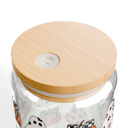 Close-up of Halloween-themed glass tumbler with a bamboo lid featuring ghost and pumpkin designs.