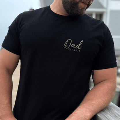 Man wearing a black t-shirt with 'Dad EST. 2026' text.