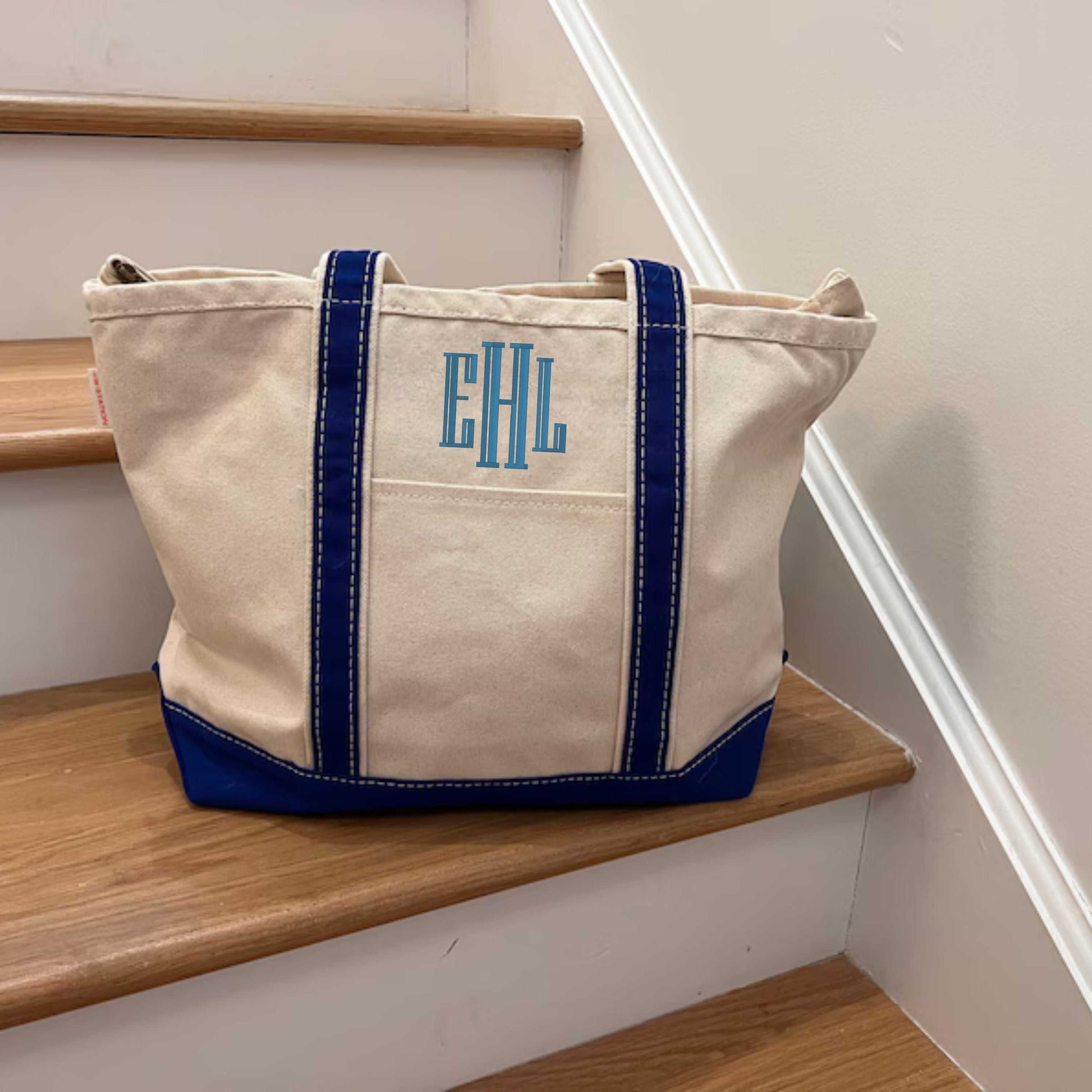 Personalized red strap canvas tote bag with embroidered name on front pocket, long shoulder handles.