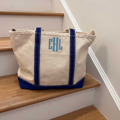 Personalized red strap canvas tote bag with embroidered name on front pocket, long shoulder handles.