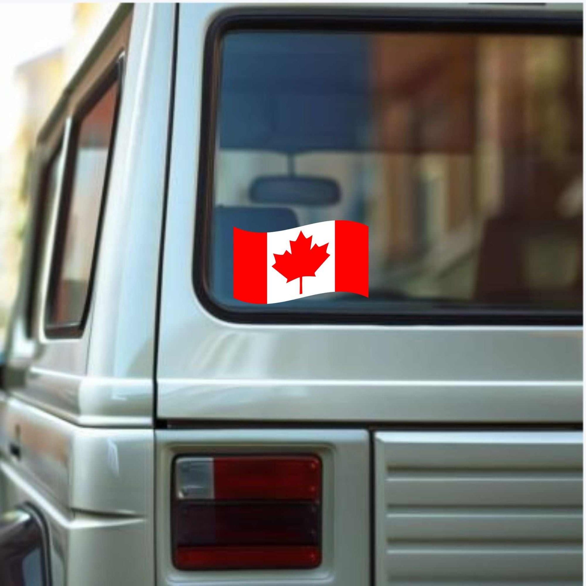 Canadian flag decal sticker on a car window, showcasing red maple leaf design.