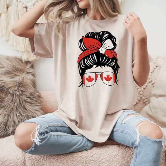 Canada-inspired unisex heavy cotton tee with a trendy graphic of a stylish updo, red bandana, and maple leaf sunglasses.
