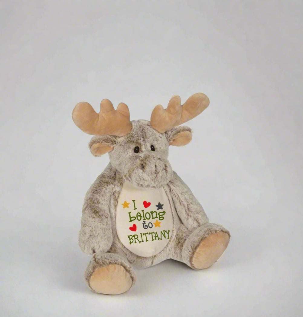 Customizable stuffed animal designed as a moose with embroidered "I Belong to Brittany" on its belly. Ideal personalized baby gift.