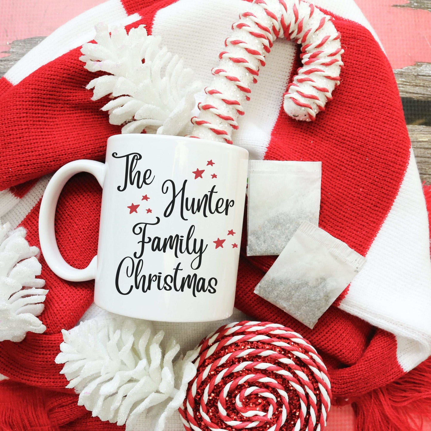 Custom Name Christmas Mug with The Hunter Family text on white enamel mug surrounded by red and white holiday decorations