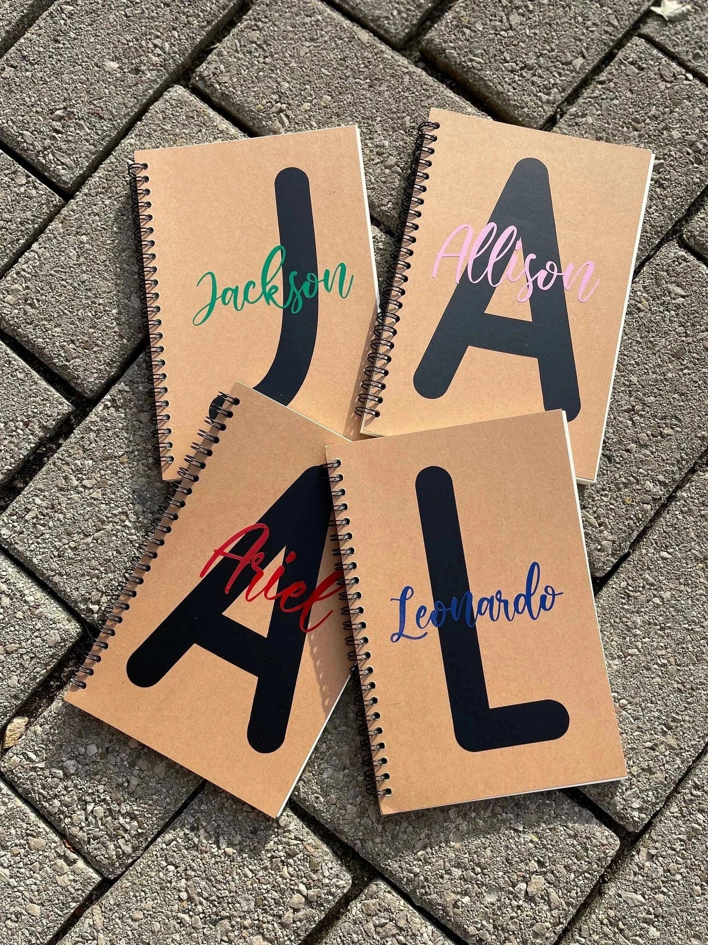 Personalized soft cover spiral notebooks with names and initials.