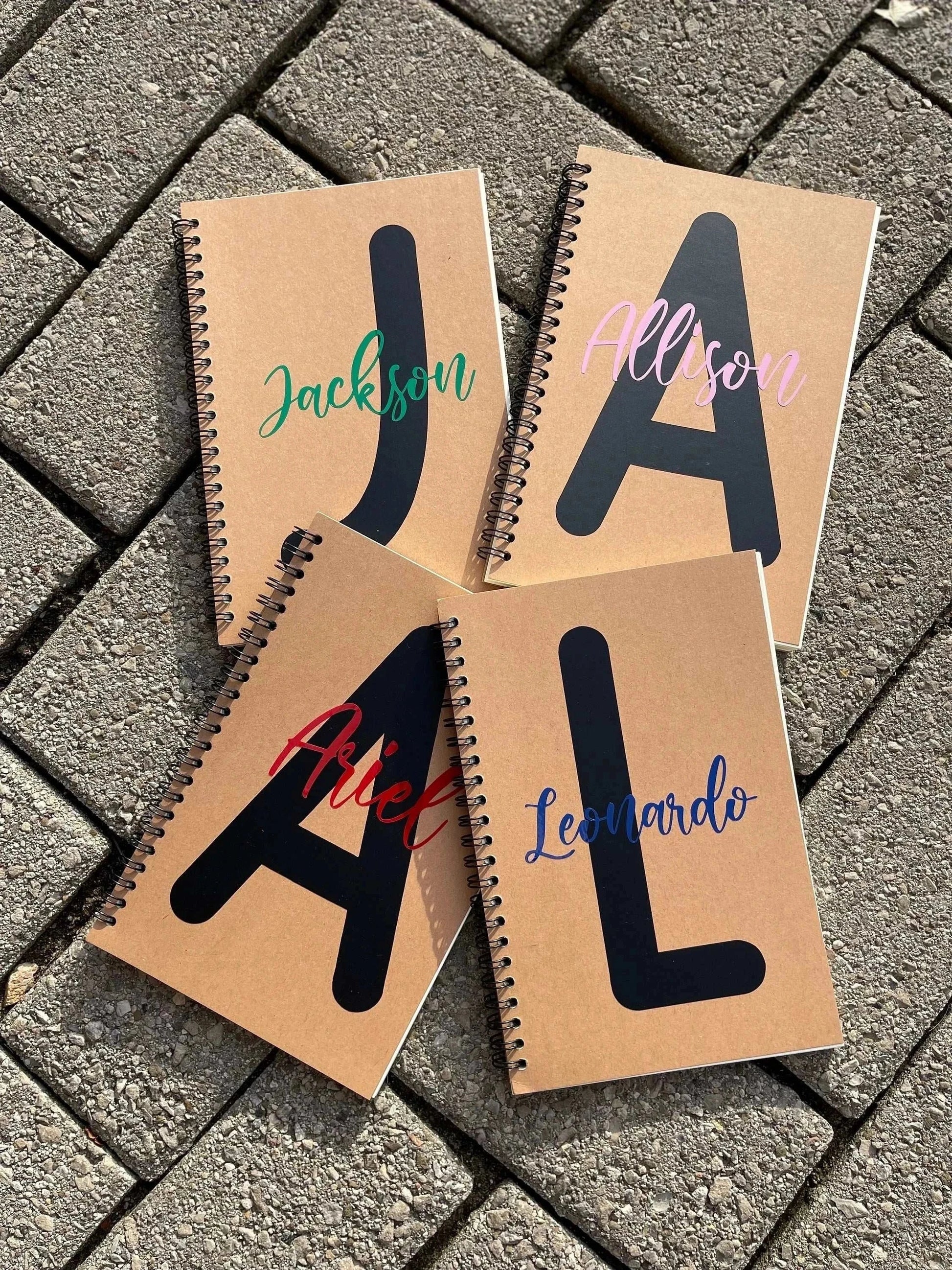 Personalized soft cover spiral notebooks with names and initials.