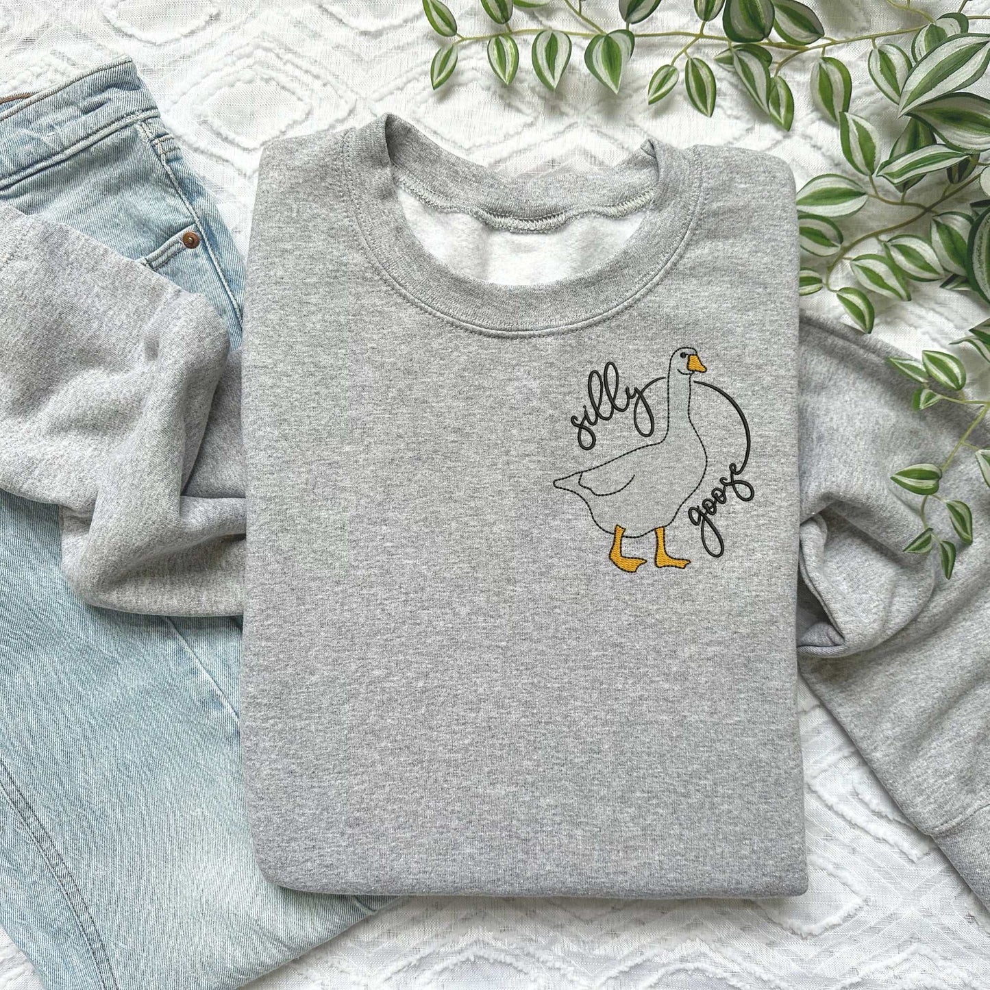Silly Goose embroidered sweatshirt with goose design on pink crewneck, soft cotton/polyester blend, unisex fit.