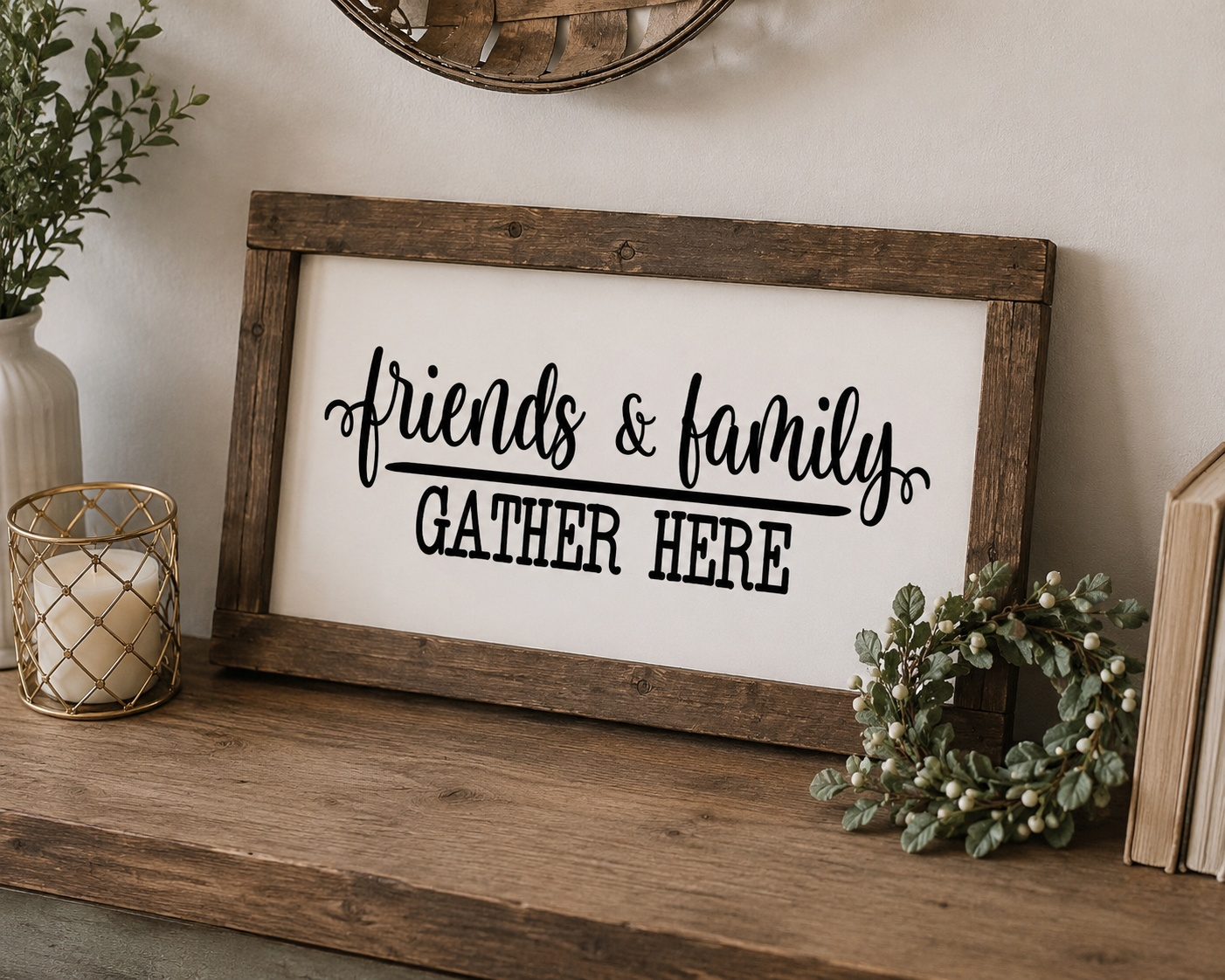 Wooden-framed sign with 'friends & family GATHER HERE' text on a wooden surface with decorative items.