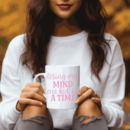 Ceramic mug with "Losing my Mind one Kid at a Time" design, perfect for moms.