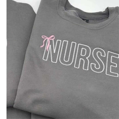 Custom embroidered "NURSE" sweatshirt with pink bow detail in gray color.