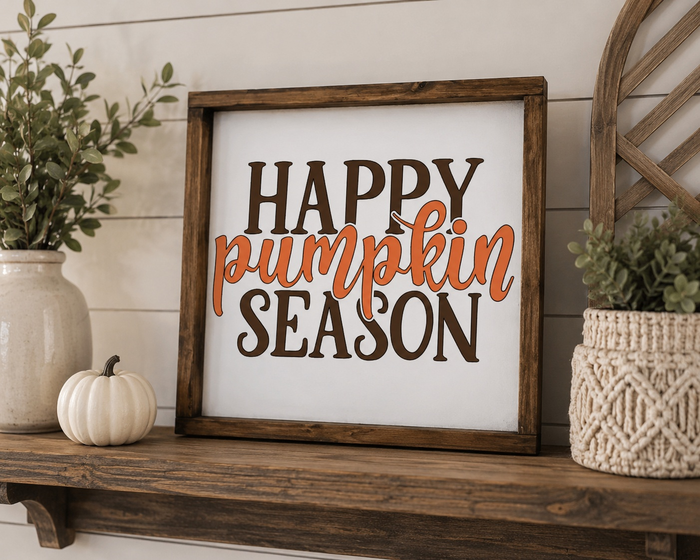 Decorative sign with 'Happy Pumpkin Season' text on a wooden shelf with plants and pumpkins.