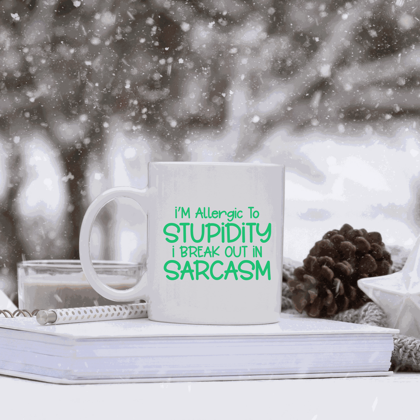 Ceramic coffee mug with "I'm Allergic to Stupidity I Break Out in Sarcasm" text in green. Perfect humorous gift.