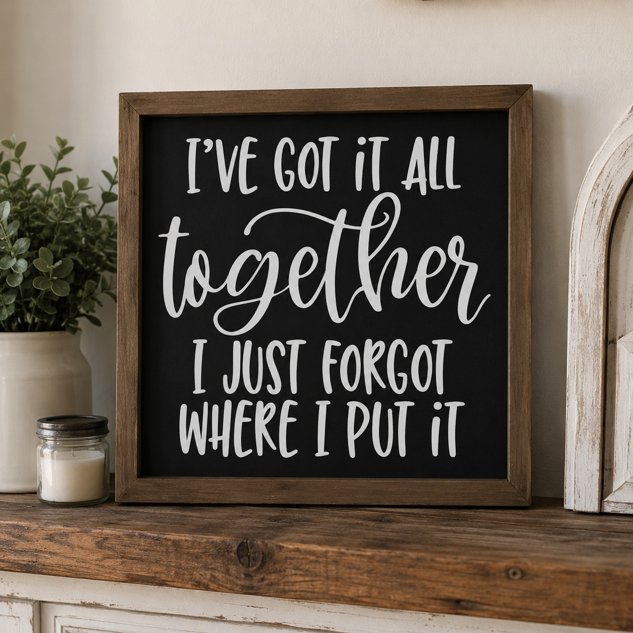 Framed sign with humorous quote on a wooden surface with decorative items.