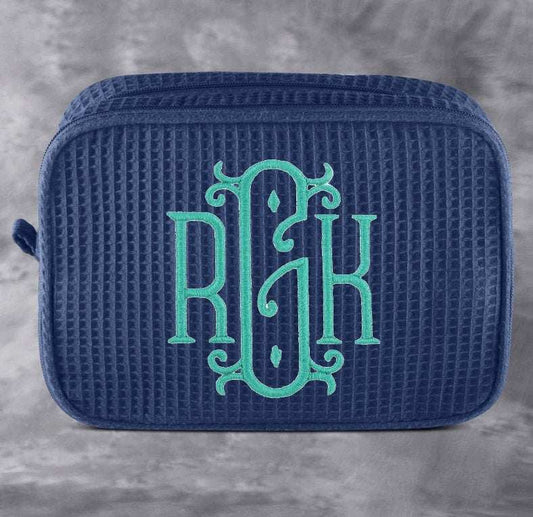 Monogrammed cosmetic bag with soft waffle texture and zipped compartments for makeup and toiletries storage