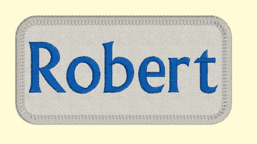 2" x 3" custom embroidered name patch with blue text "Robert" on a grey background for jackets.
