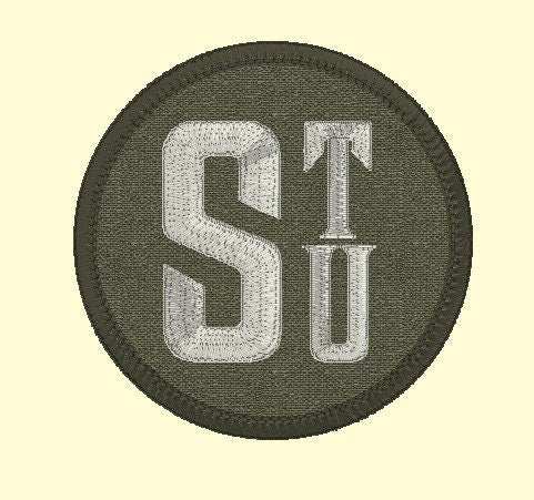 3-inch round custom name patch with initials "STU" embroidered on dark fabric.