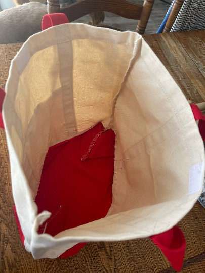 Open personalized embroidered tote bag with red interior and long handles, showcasing spacious design for versatile use.