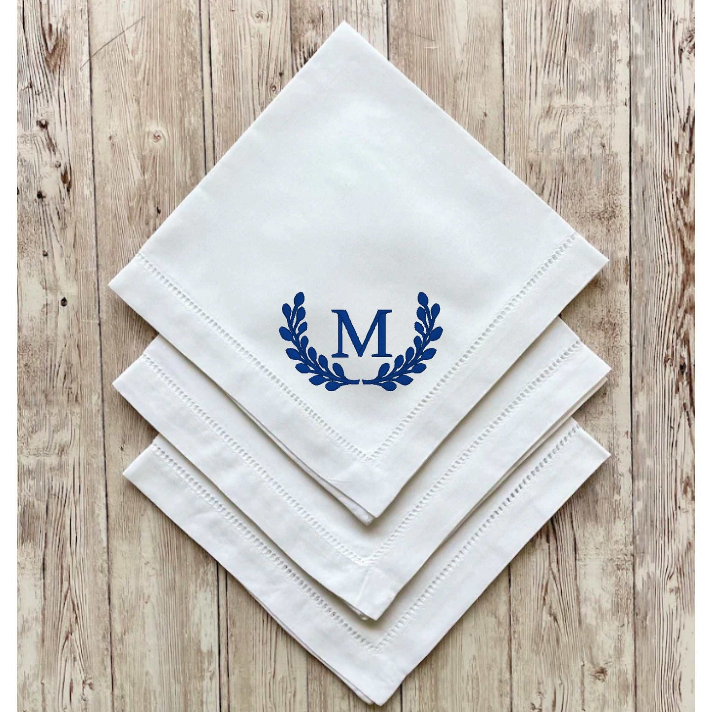 Set of white linen blend dinner napkins with embroidered blue initial and hemstitch detailing