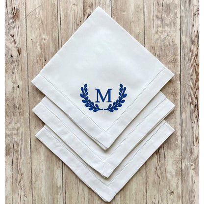Set of white linen blend dinner napkins with embroidered blue initial and hemstitch detailing