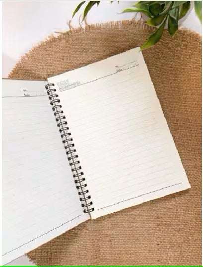 Open personalized spiral-bound notebook with lined pages on a burlap surface.
