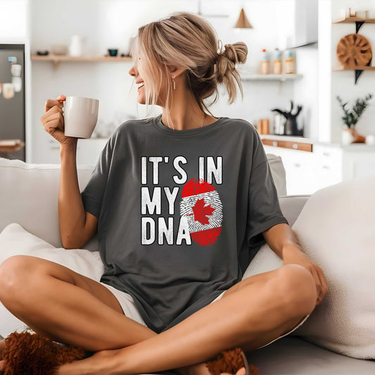 Canadian patriotic T-shirt with fingerprint and maple leaf design, worn by woman holding a mug, ideal for Canada Day.