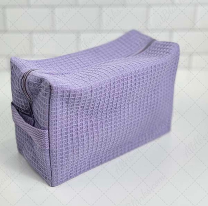 Monogrammed cosmetic bag with soft waffle texture and zipped compartments for makeup storage