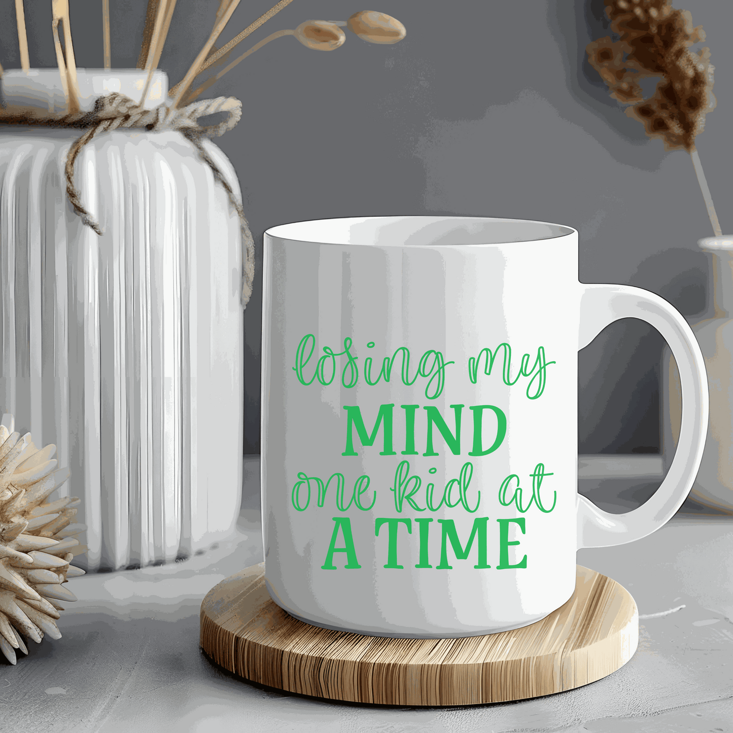 Ceramic mug with "Losing My Mind One Kid at a Time" text, 15 ounces, humorous gift for moms, white and glossy.