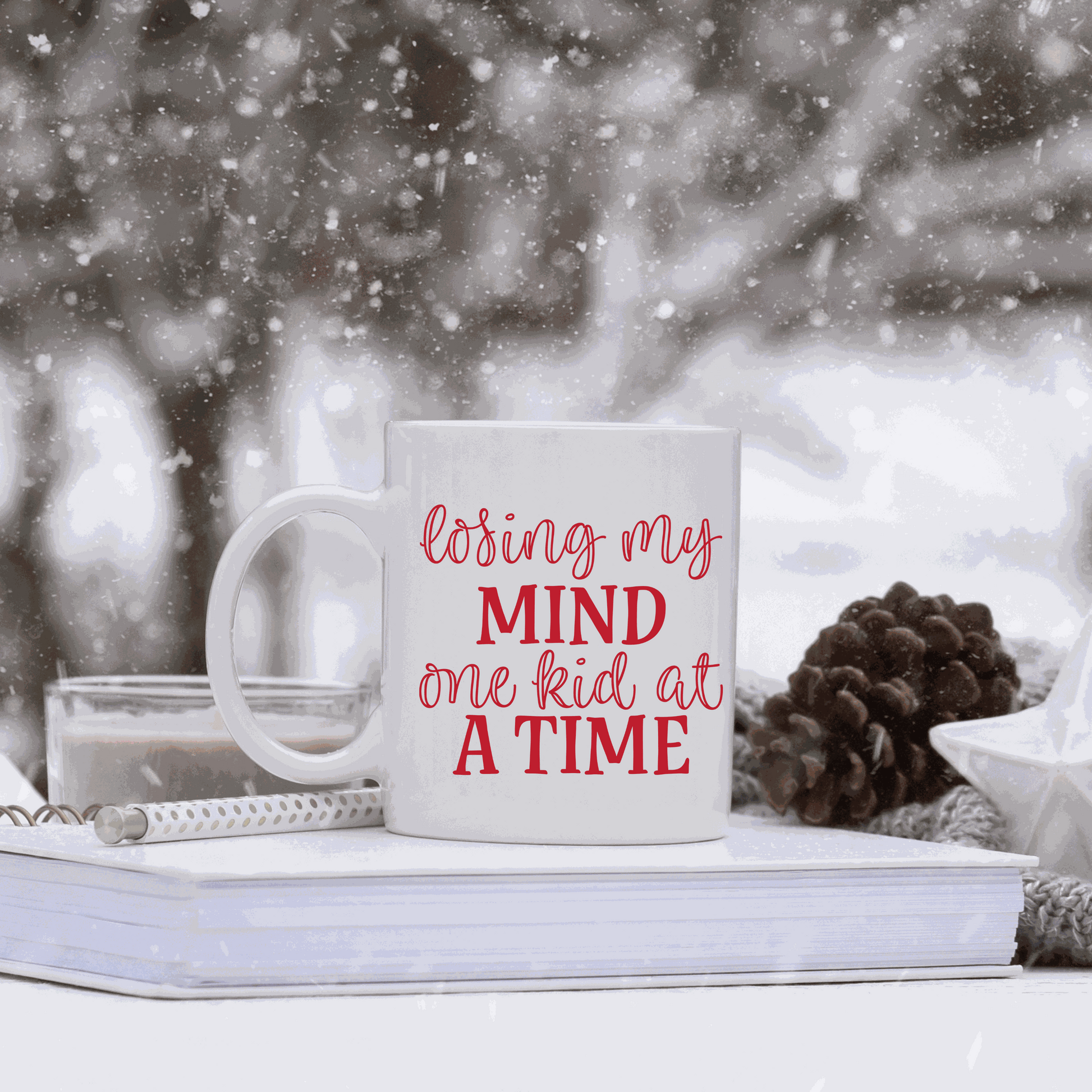White ceramic mug with humorous "Losing my Mind one Kid at a Time" design.