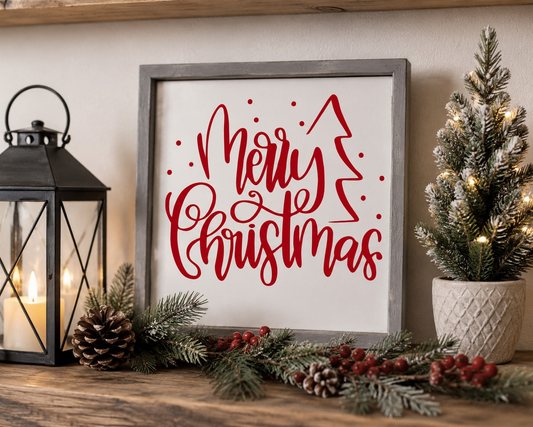 Framed 'Merry Christmas' sign with decorative elements on a wooden surface.