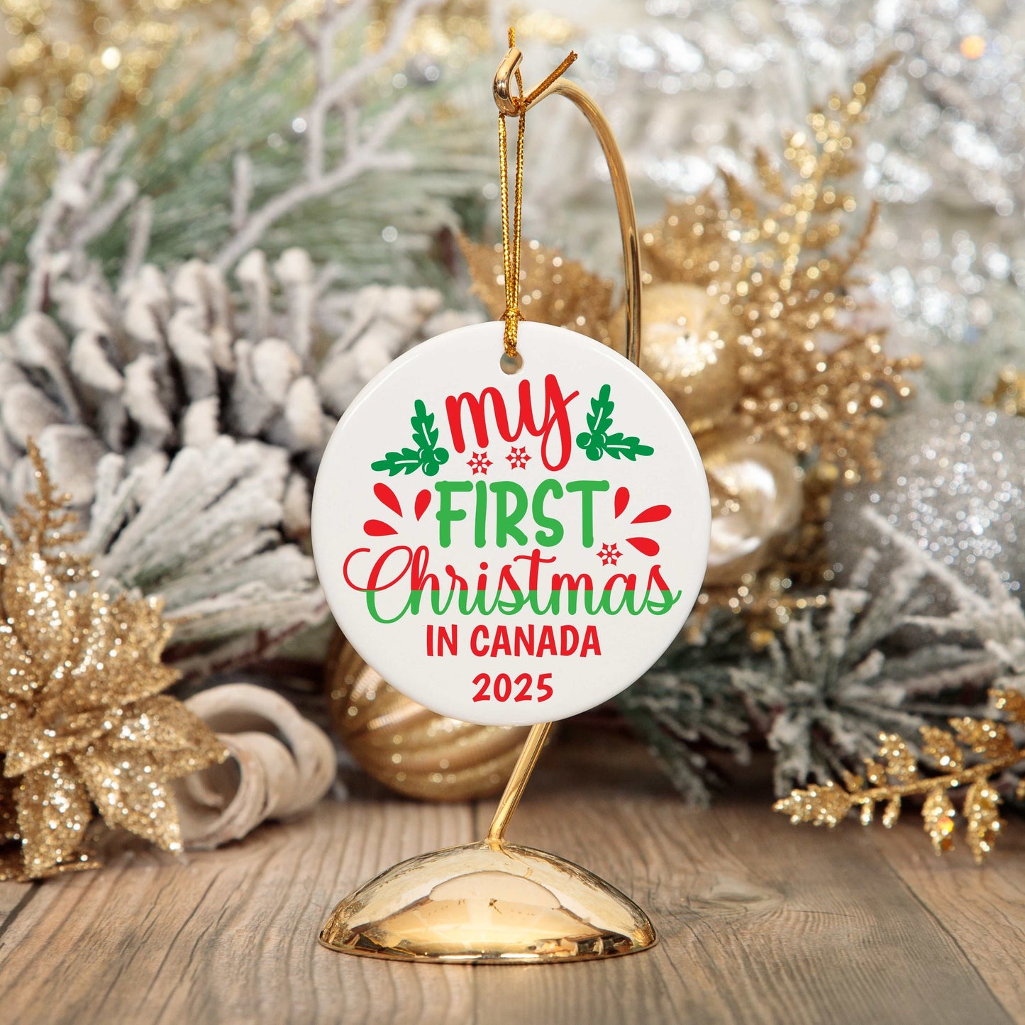 Round ceramic Christmas ornament with "My First Christmas in Canada 2025" text, gold string, festive background