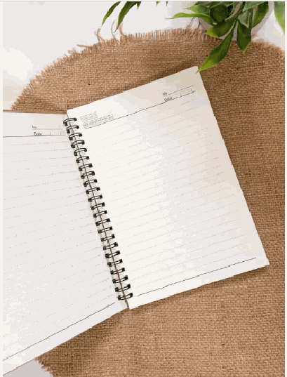 Personalized soft cover spiral notebook, 8x5.5 inches, kraft cover, open on burlap mat with greenery.